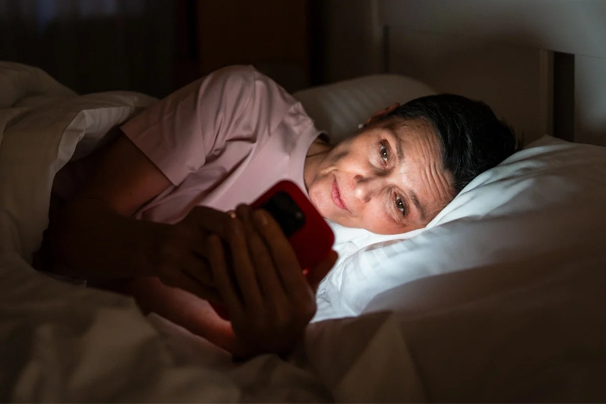Woman looking at her phone at night in bed