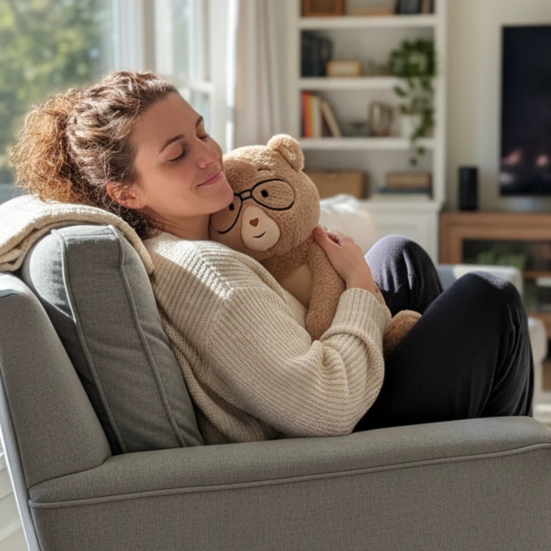 Woman snuggling with Percy the 5 lb. comfort bear on a grey arm chair